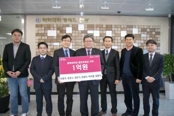 충북대학교는 약학대학 발전을 위해 지역 기업인 및 연구자들이 시설기금 1억원을 기턱하고 기념촬영을 하고 있다.