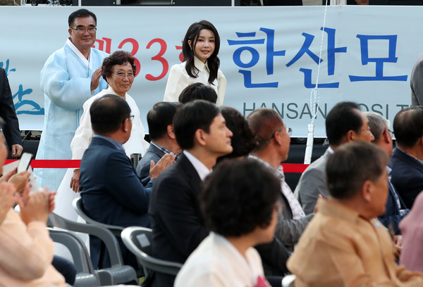 김건희 여사는 한산모시로 만든 검은색 치마와 흰색 상의을 착용하고 김기웅 서천군수와 함께 개막식장에 입장하고 있다.(대통령실통신사진기자단)